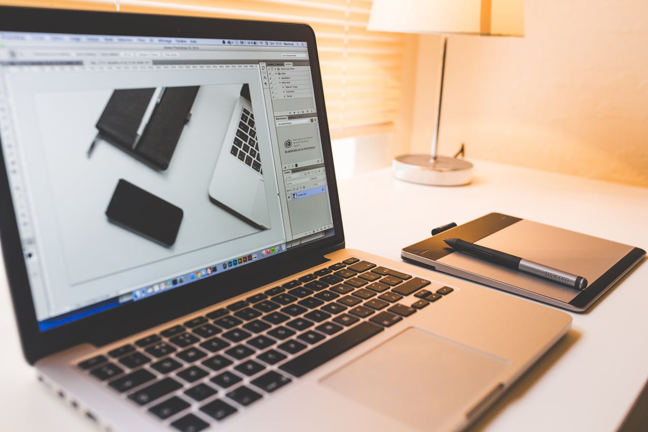 Modern workspace featuring a laptop, digital pen, and pad for creative work.